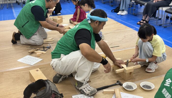 二人三脚で完成を目指す＝8月4日、横浜市技能文化会館