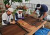 網戸を張替える穐元青年部長（左）と松井支部執行委員長（中央）＝6月15日、日吉本町